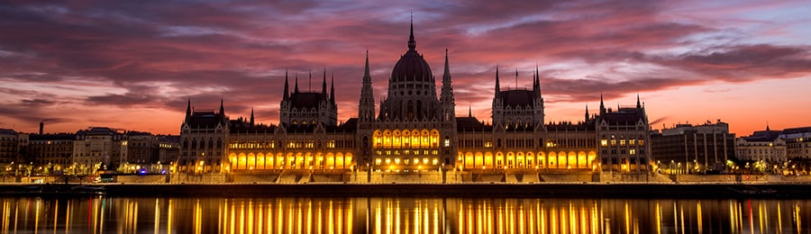 ブダペストにあるハンガリーの国会議事堂からの光が水面に反射している景色