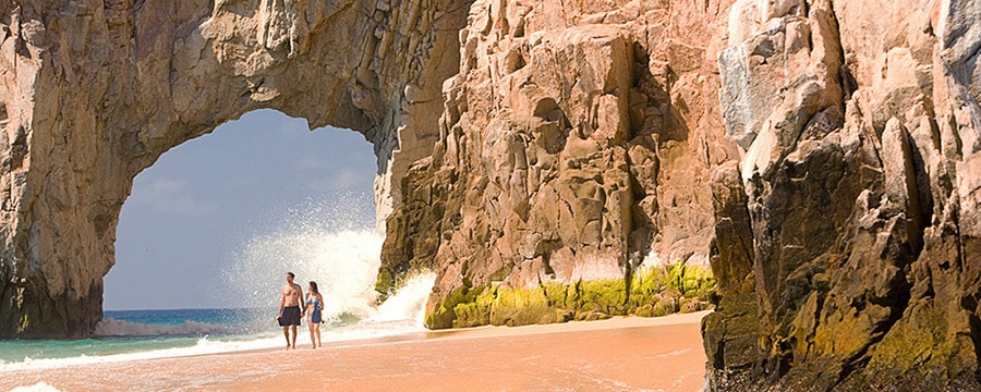 メキシコ、サンルーカス岬のエル・アルコそばのビーチを手をつないで歩くカップル
